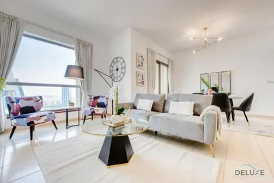 a living room with a couch and a table at Vogue 2BR at Shams 2 JBR by Deluxe Holiday Homes in Dubai