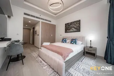 a bedroom with a large bed and a desk in it at Farhad Exclusive Studio Suite in Dubai