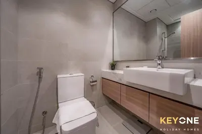 a bathroom with a toilet and a sink and a mirror at Farhad Exclusive Studio Suite in Dubai
