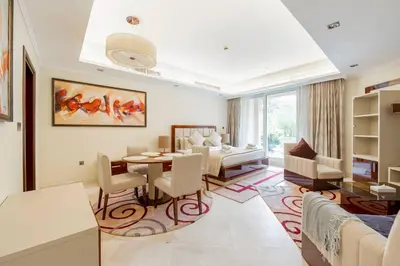 a living room with a table and a dining room at Fully-equppied studio with private beach and pool in Dubai