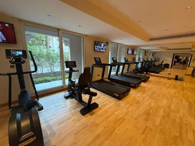 a gym with a row of treadmills and ellipticals at Fully-equppied studio with private beach and pool in Dubai