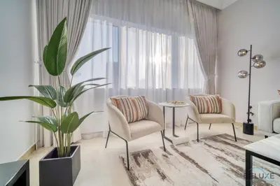 a living room with two chairs and a table and a plant at Opulent 1BR at MAG 218 Dubai Marina by Deluxe Holiday Homes in Dubai