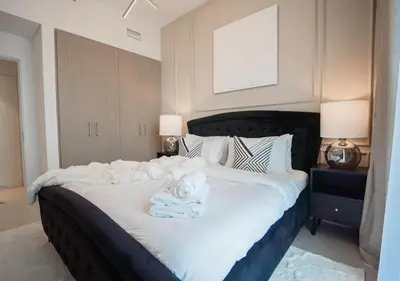 a bedroom with a large bed with towels on it at Nasma Luxury Stays - The Grand, Dubai Creek Harbour in Dubai