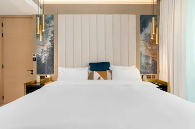 a bedroom with a large white bed with blue accents at Lux BnB I The Address JBR I Ocean View in Dubai