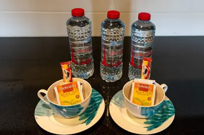 a table with two cups and two bottles of water at Lux BnB I 29 Burj BLVD I Downtown Views in Dubai