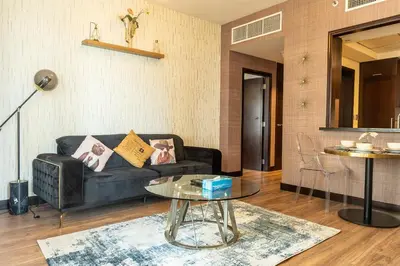 a living room with a couch and a table at BellaVista 29 Boulevard 1 Bedroom Apartment with Extra Bedroom Partial Fountain Views in Dubai