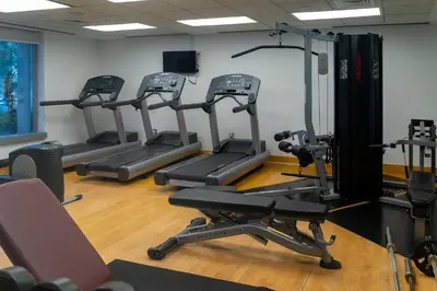 a gym with several tread machines in a room at BellaVista 29 Boulevard 1 Bedroom Apartment with Extra Bedroom Partial Fountain Views in Dubai