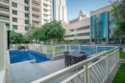 a balcony with a table and a swimming pool at BellaVista 29 Boulevard 1 Bedroom Apartment with Extra Bedroom Partial Fountain Views in Dubai
