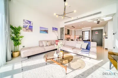 a living room with a couch and a table at Splendid 2BR at Sunrise Bay Tower 1 Emaar Beachfront Dubai Marina by Deluxe Holiday Homes in Dubai