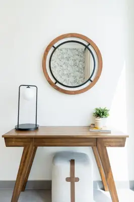 a wooden table with a mirror on a wall at ON OFF HH- CREEK HARBOUR-Lavish Parisian 2 BR in Dubai