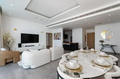 a living room with a table and white furniture at Oceana Residences, The Palm Jumeirah - Mint Stay in Dubai