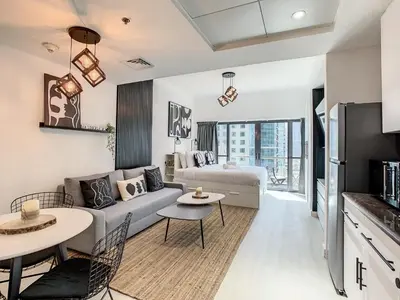 a living room with a couch and a table at Luxury Modern Studio in JLT - Rooftop Pool - Lake Area Upgrades Ongoing in Dubai