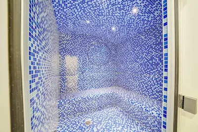 a bathroom with a blue tiled shower with a tub at Modern City Retreat Vera Residence, Business Bay in Dubai