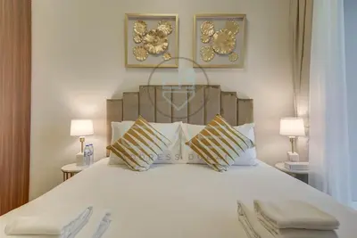 a bedroom with a large white bed with two lamps at Modern City Retreat Vera Residence, Business Bay in Dubai