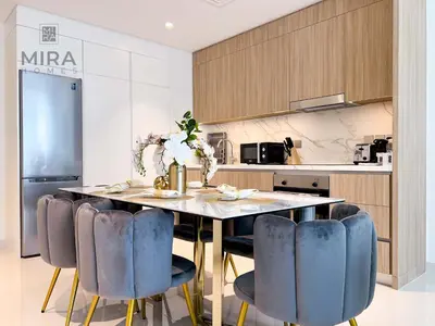 a kitchen with a table with blue chairs at Mira Holiday Homes - Newly 1 bedroom apartment with beach access in Dubai