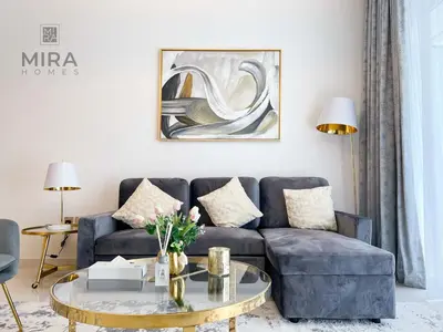 a living room with a blue couch and a coffee table at Mira Holiday Homes - Newly 1 bedroom apartment with beach access in Dubai