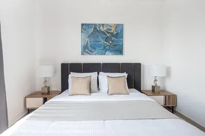 a bedroom with a large white bed with two lamps at Frank Porter - Bay Central West 2 in Dubai