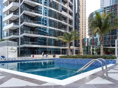 a swimming pool in front of a tall building at Frank Porter - Bay Central West 2 in Dubai
