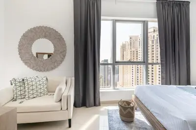 a bedroom with a bed and a mirror and a chair at Frank Porter - Bay Central West 2 in Dubai