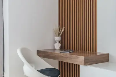 a wooden accent wall with a table and a chair at GuestReady - Chic Studio in Urban JLT in Dubai