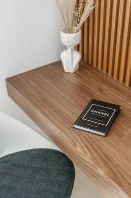a book on a wooden table with a vase at GuestReady - Chic Studio in Urban JLT in Dubai