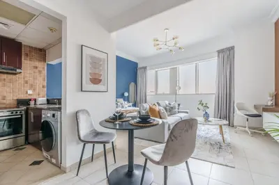 a kitchen and living room with a table and chairs at GuestReady - Chic Studio in Urban JLT in Dubai