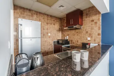 a kitchen with a sink and a refrigerator at GuestReady - Chic Studio in Urban JLT in Dubai