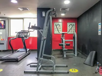 a gym with two tread machines and a red wall at GuestReady - Chic Studio in Urban JLT in Dubai