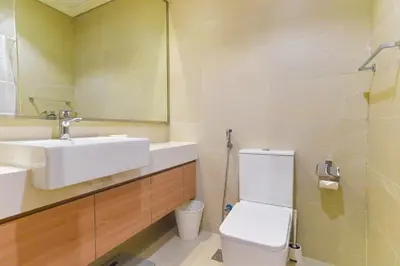 a bathroom with a sink and a toilet and a mirror at Luxury Escapes - Brand New Studio with View - Azizi Farhad Jaddaf in Dubai