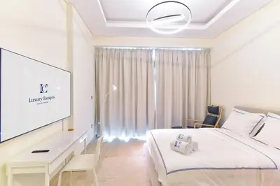 a hotel room with a bed and a flat screen tv at Luxury Escapes - Brand New Studio with View - Azizi Farhad Jaddaf in Dubai