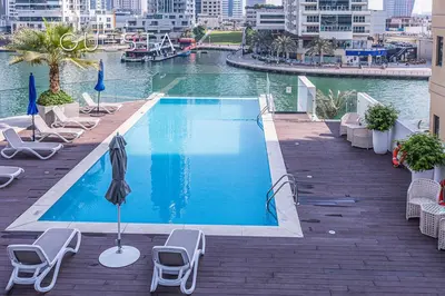 a swimming pool with chairs and an umbrella on a balcony at LIV Residence Tower, Dubai Marina in Dubai