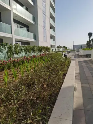 a sidewalk in front of a building with plants at Gharfar-2 Heaven Escape-Golf view-high floor-Netflix-GYM-Pool-perfect staycation in Dubai