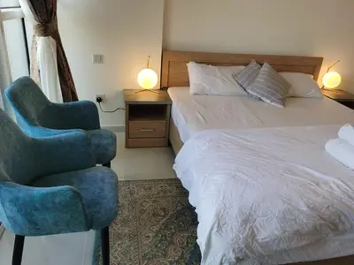 a bedroom with a bed and a blue chair at Gharfar-2 Heaven Escape-Golf view-high floor-Netflix-GYM-Pool-perfect staycation in Dubai