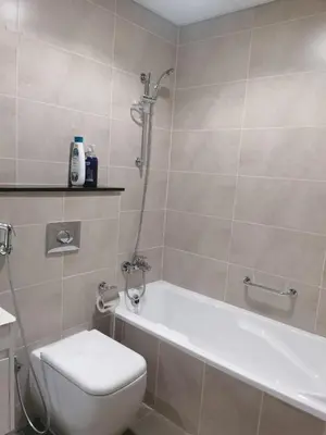 a bathroom with a shower and a toilet and a tub at Gharfar-2 Heaven Escape-Golf view-high floor-Netflix-GYM-Pool-perfect staycation in Dubai