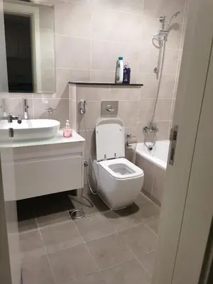 a bathroom with a toilet and a sink and a tub at Gharfar-2 Heaven Escape-Golf view-high floor-Netflix-GYM-Pool-perfect staycation in Dubai