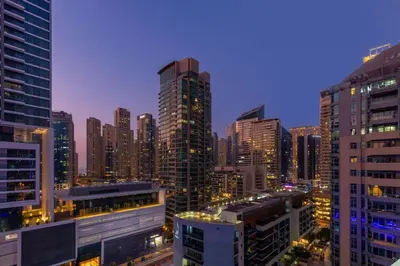 a city skyline at night with tall buildings at Horizon Tower - Stunning Four Bedroom in Dubai