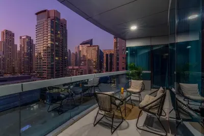a balcony with chairs and tables and a city skyline at Horizon Tower - Stunning Four Bedroom in Dubai
