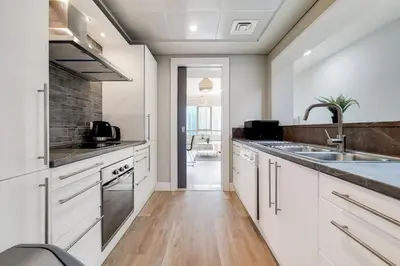a kitchen with white cabinets and a sink at Al Majara 2 - Gorgeous One Bedroom in Dubai