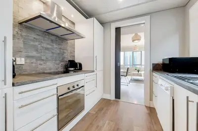 a kitchen with white cabinets and a stove top oven at Al Majara 2 - Gorgeous One Bedroom in Dubai