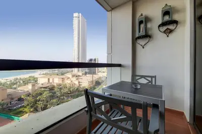 a table and chair in a room with a large window at Sadaf 6, JBR - Remarkable Two Bedroom in Dubai