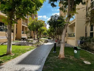a walkway in a park with trees and buildings at Gorgeous One Bedroom Apartment in the heart of Dubai in Dubai