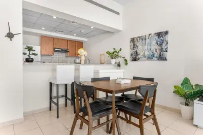 a kitchen and dining room with a wooden table and chairs at Gorgeous One Bedroom Apartment in the heart of Dubai in Dubai