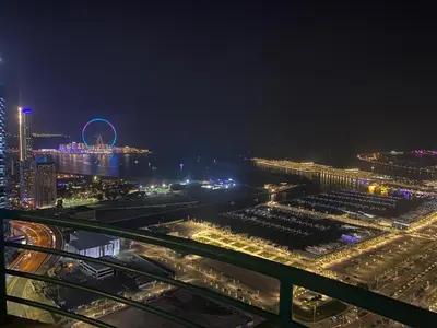 a view of a city at night with a ferris wheel at Marina Crown Tower Stays Hostel for Girls in Dubai