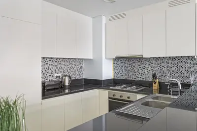a kitchen with white cabinets and a sink at ALiving Luxury 2BR with Infinity Pool I Near Dubai Mall & Burj Khalifa I Paramount Hotel Midtown in Dubai