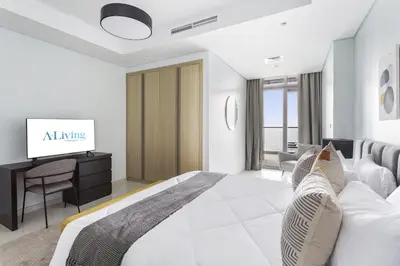 a white bedroom with a bed and a tv at ALiving Luxury 2BR with Infinity Pool I Near Dubai Mall & Burj Khalifa I Paramount Hotel Midtown in Dubai