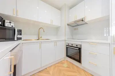 a kitchen with white cabinets and a sink and a microwave at EDEN'S Homes & Villas - Anantara The Palm Residences in Dubai