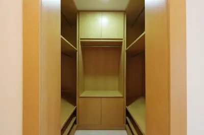 a walk in closet with wooden cabinets and green shelves at Livbnb Suites - 1BR with Sea View & Beach Access in Dubai