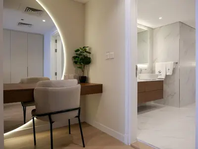 a bathroom with a sink and a table and a mirror at Lovely 1 bedroom apartment at 5 Star Resort in Dubai