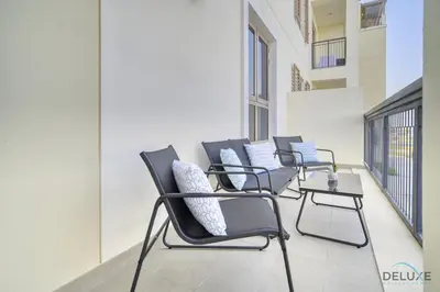 a row of chairs sitting on a balcony at Placid 1BR at La Cote 5 Jumeirah 1 by Deluxe Holiday Homes in Dubai