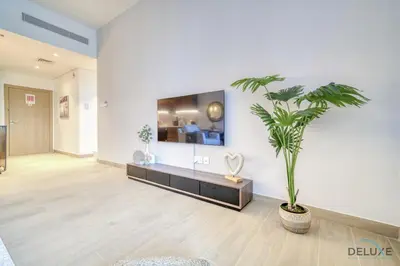 a living room with a potted plant on the wall at Placid 1BR at La Cote 5 Jumeirah 1 by Deluxe Holiday Homes in Dubai